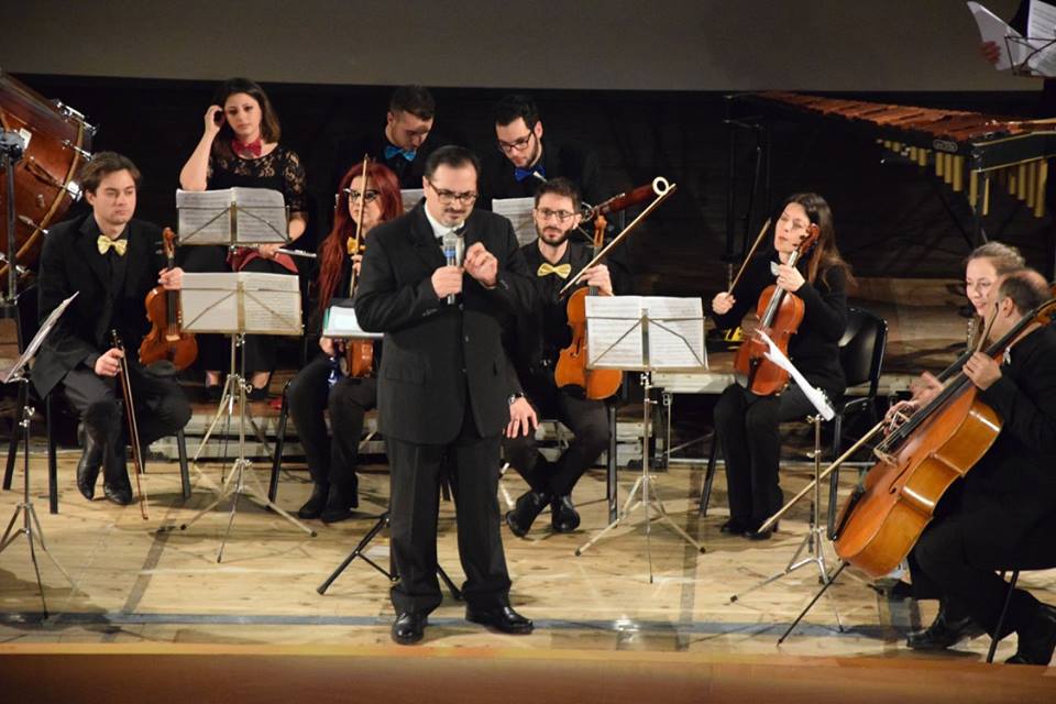 Il M° Chillemi con il microfono davanti all'orchestra