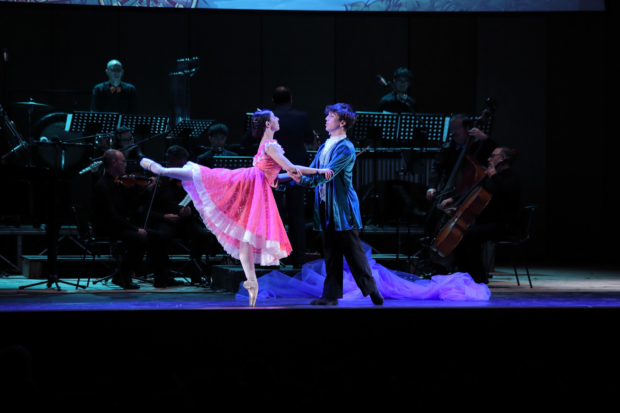 Pas de deux — ballerina in tutù rosa con il principe, orchestra sullo sfondo 2024